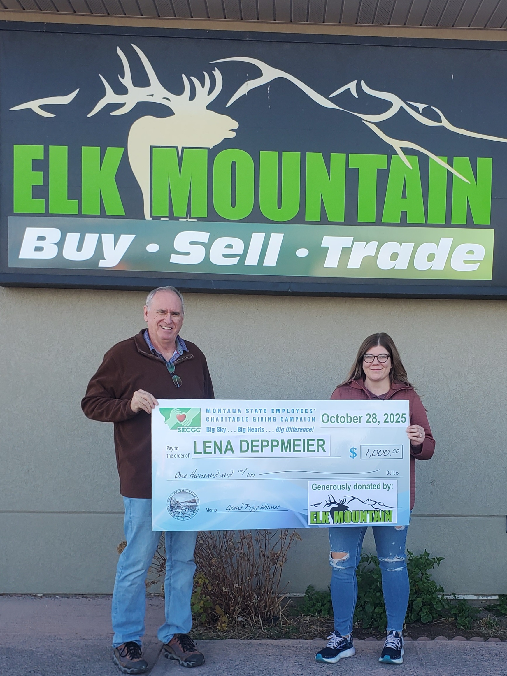 Elk Mountain and Lena Deppmeier holding the $1,000 check.